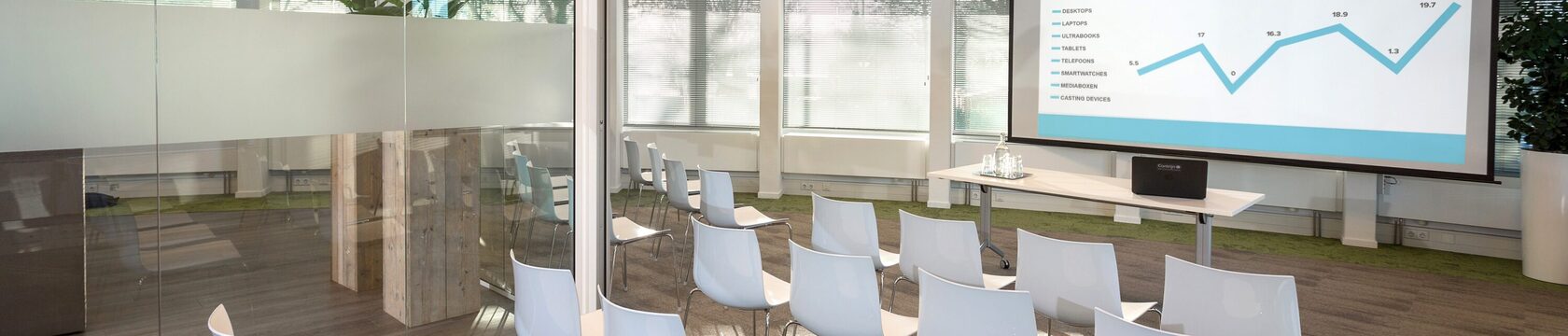 Een vergaderzaal met stoelen en een scherm
